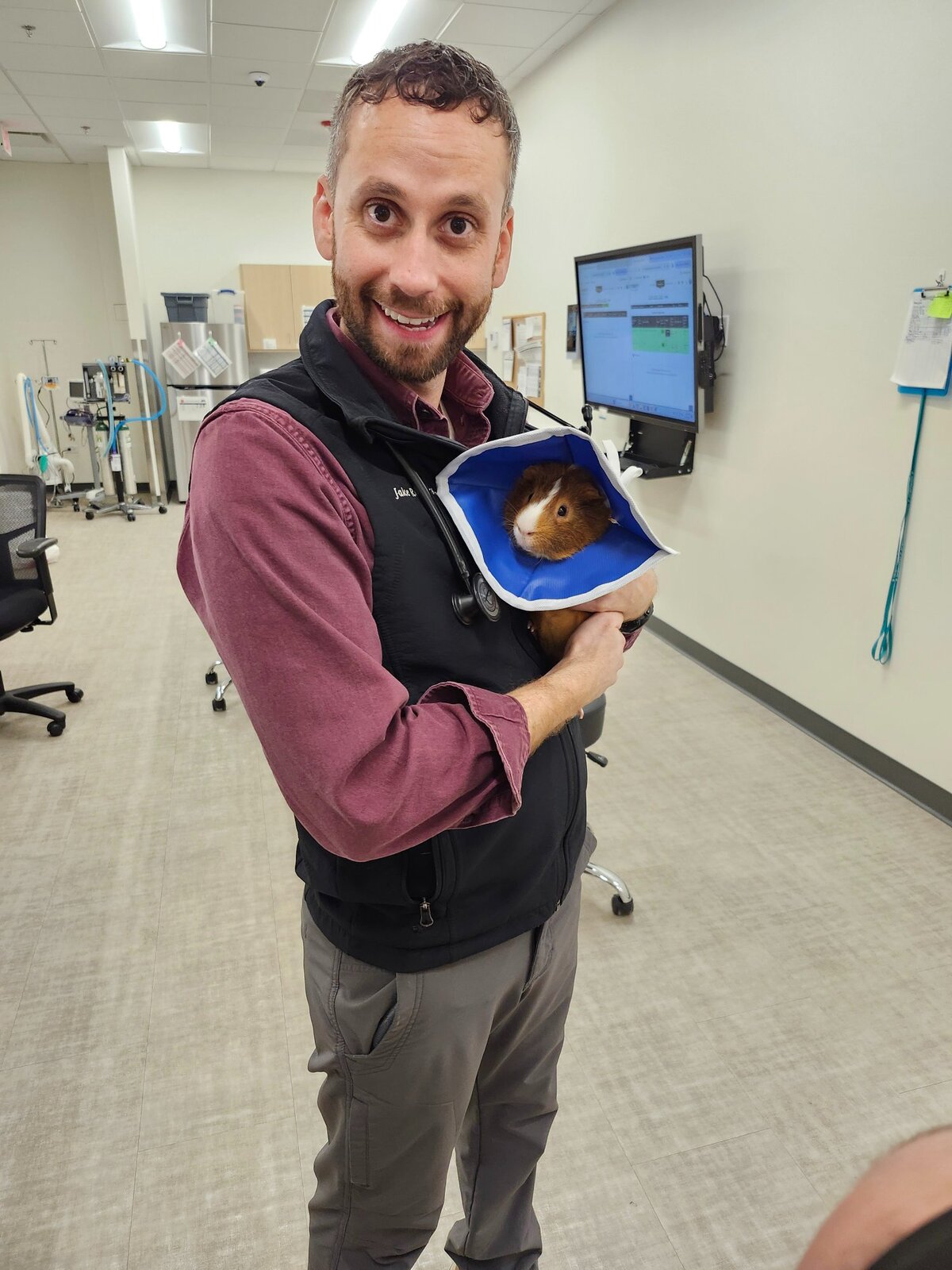 Dr. Jake Rodgers, DVM holding a guinea pig patient in the clinic — Vet Buddies founder